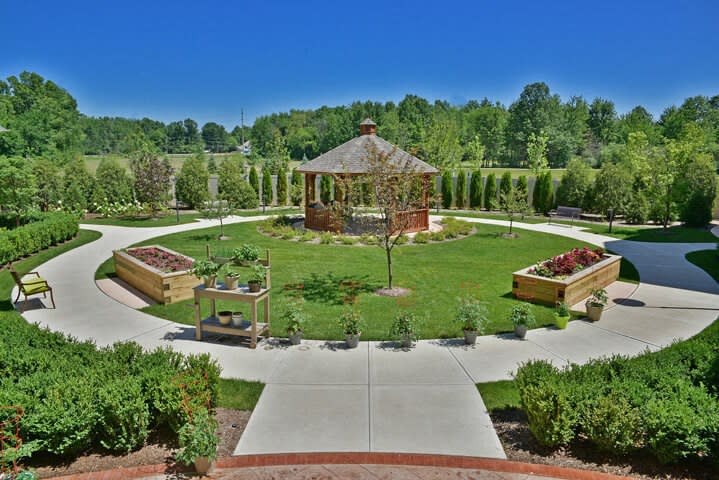 A well-maintained park featuring a central gazebo surrounded by landscaped paths and greenery.