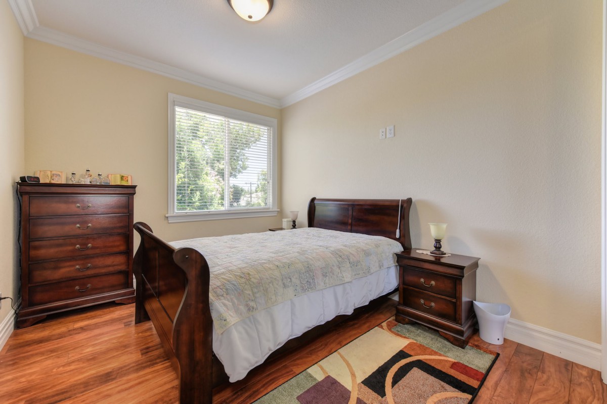 A traditional bedroom with wooden furniture and a large window.