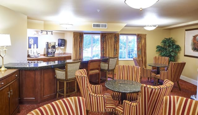 Cozy lounge area with striped chairs and a bar counter.