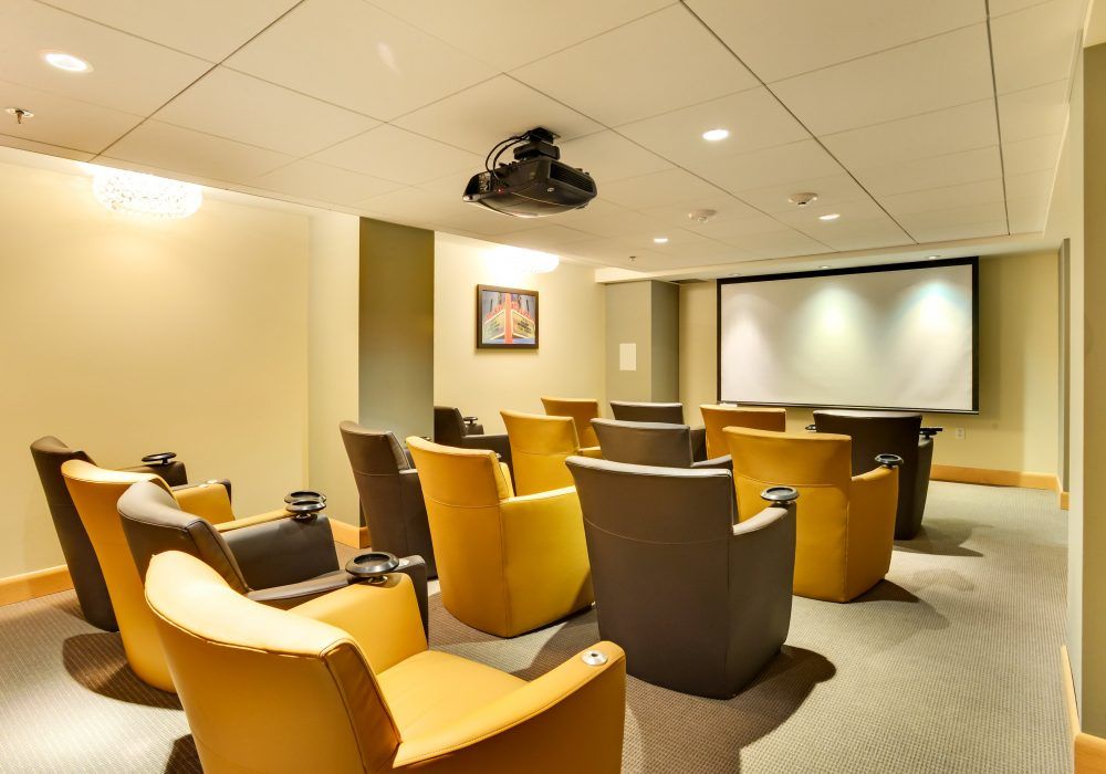 A cozy home theater room with comfortable seating and a large screen for viewing.