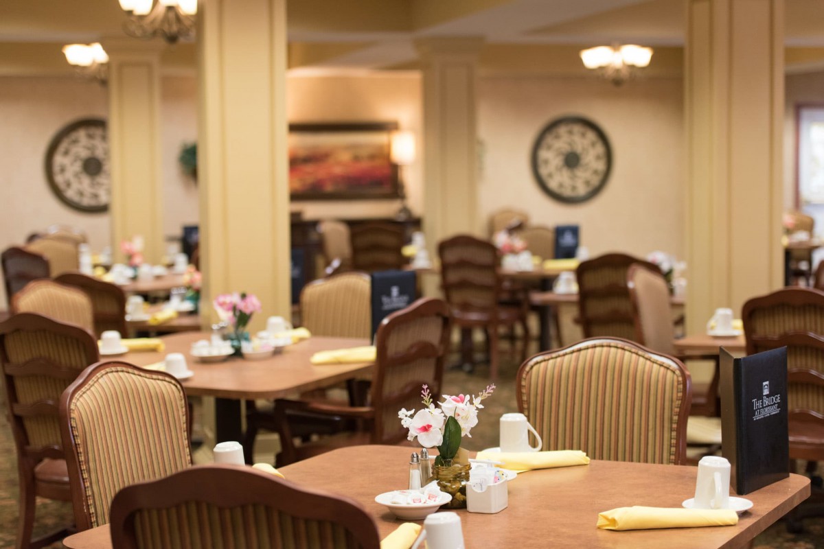 A cozy and elegant dining room with neatly arranged tables and chairs.