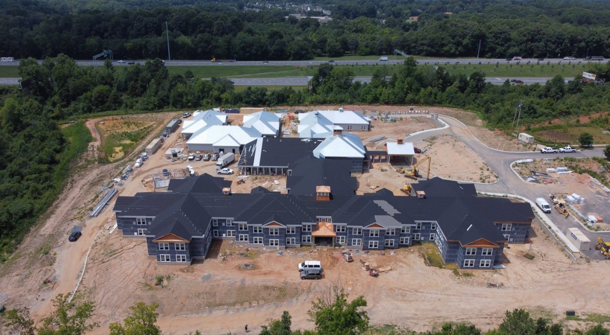 Aerial view of a construction site with partially completed buildings and roofing.