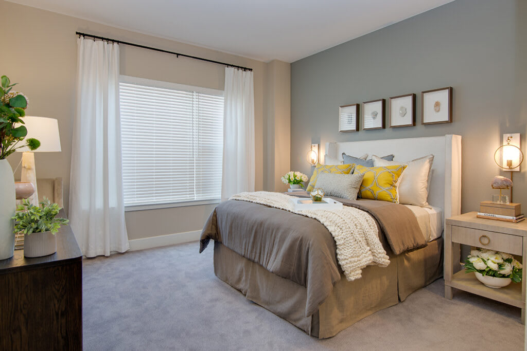 A modern bedroom with neutral tones and cozy decor.
