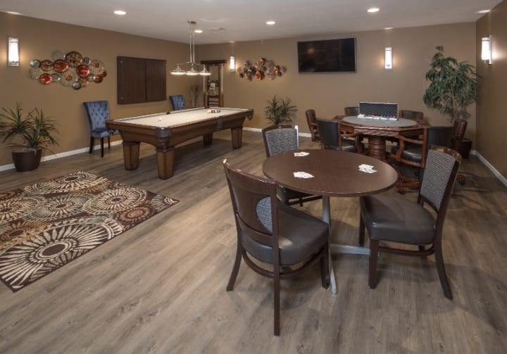 A modern game room featuring a billiards table, seating area, and contemporary decor.