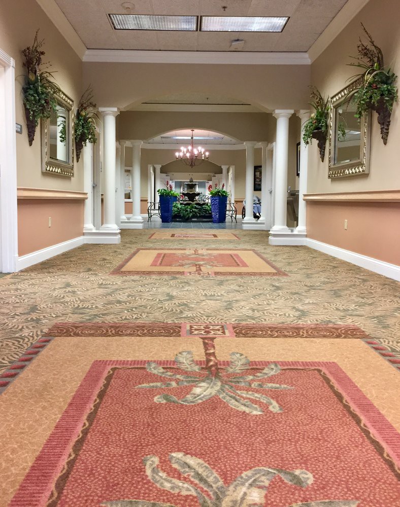 A spacious hallway with carpets and decorative columns.
