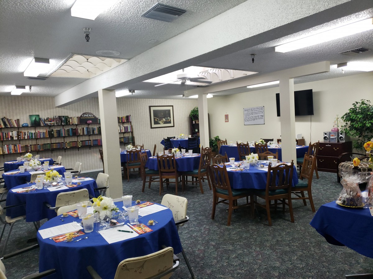 A banquet hall set up with blue tablecloths, ready for an event.
