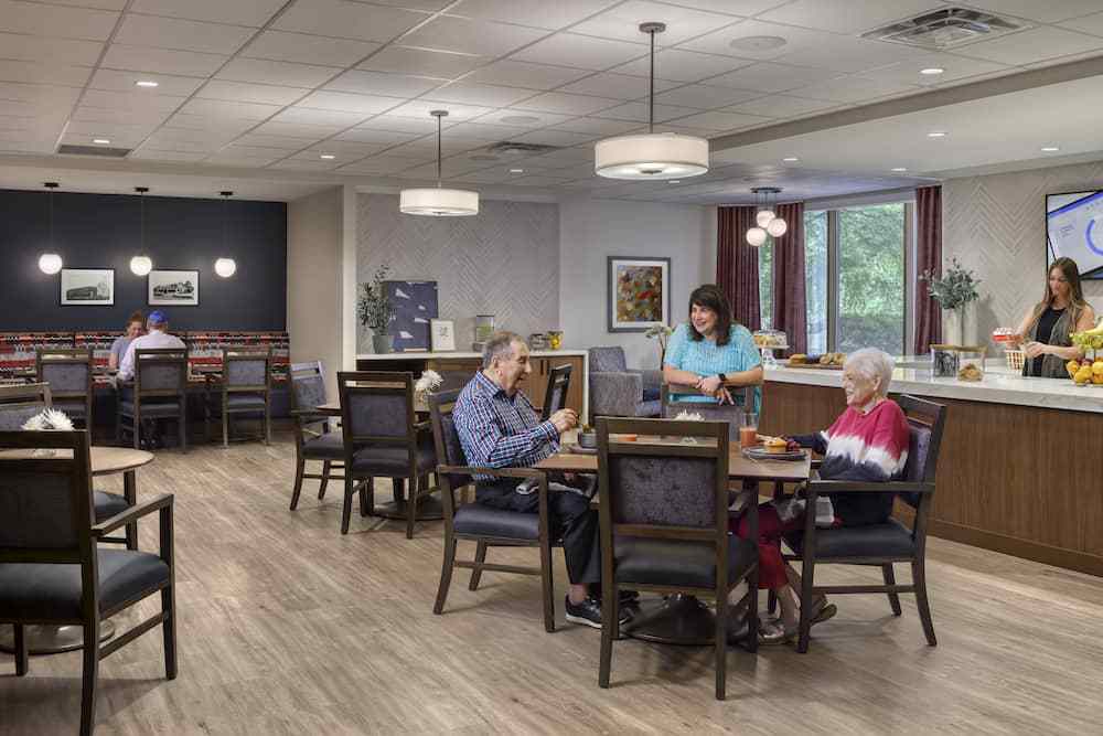 A calm and inviting dining area in a care facility where seniors are enjoying a meal together.