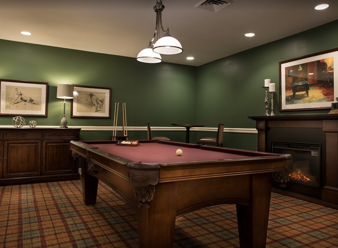 A cozy billiard room with a pool table and classic decor.