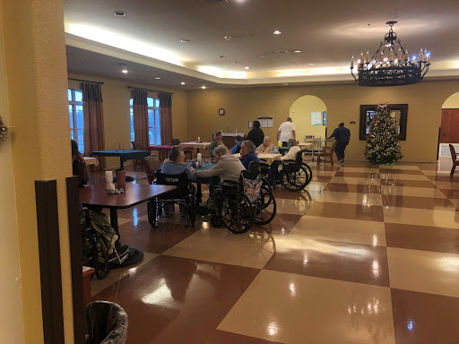 A spacious activity room in a senior living facility, where residents engage in various activities.