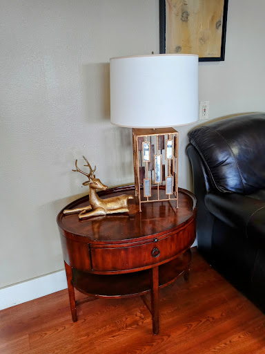 A stylish wooden side table with a lamp and decorative antler in a cozy living room setting.