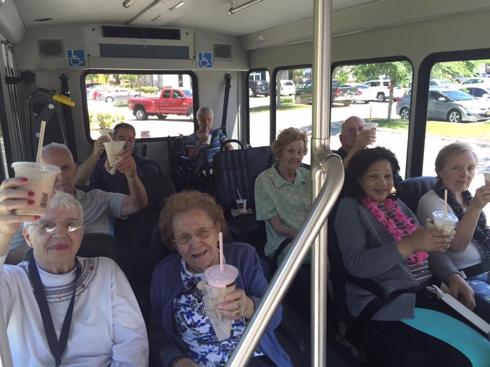 A group of elderly individuals enjoying a bus ride together.