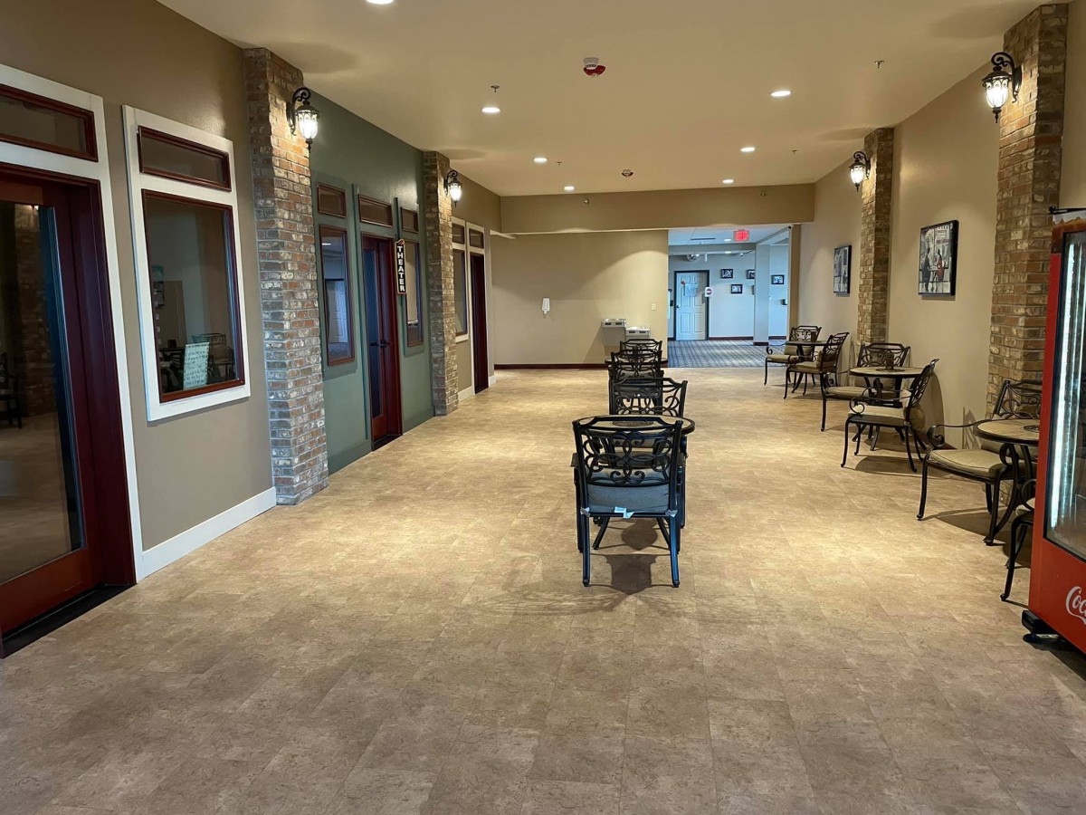 A well-lit hallway with chairs and decor.