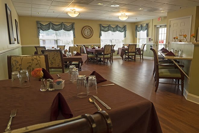 A cozy dining area set with tables and chairs, ready for guests.