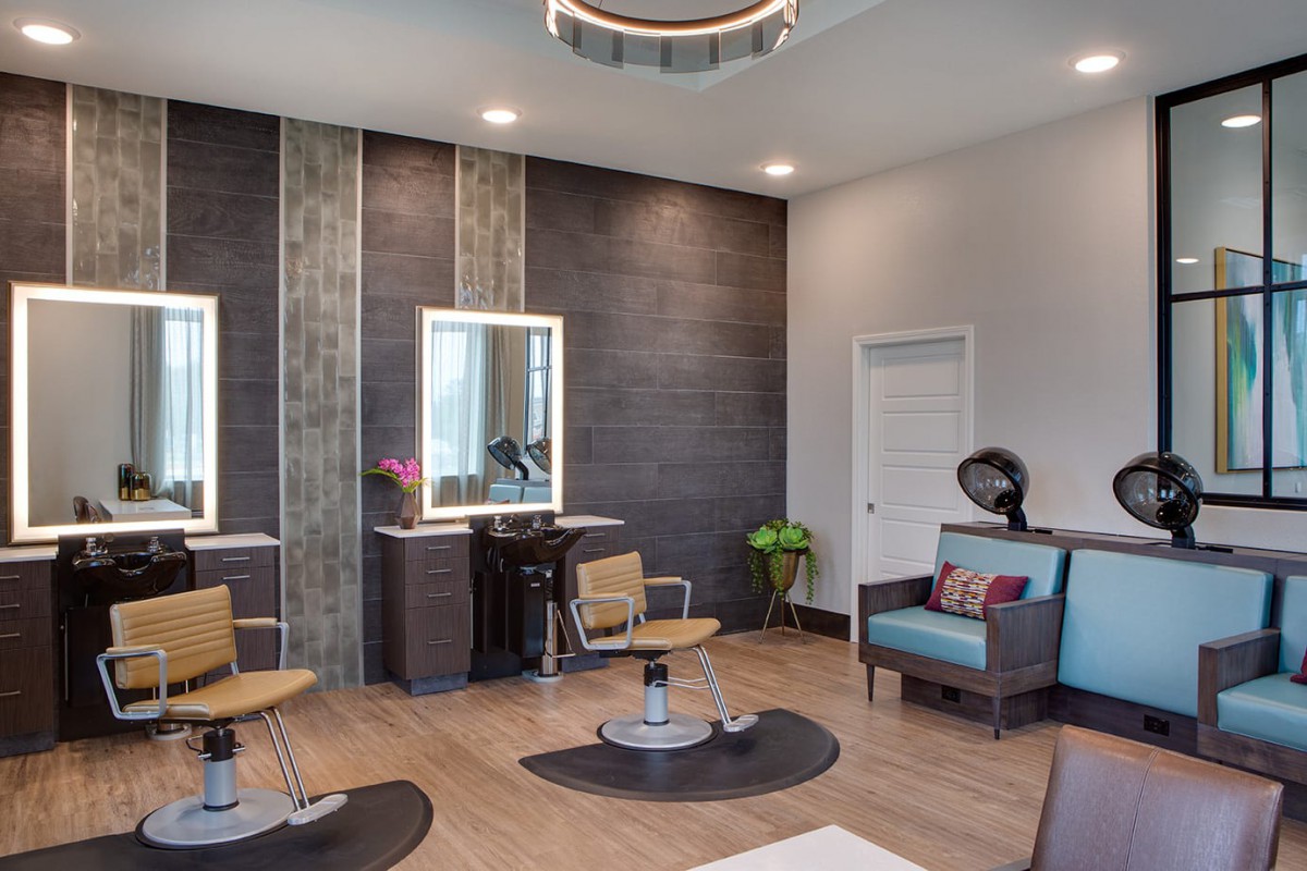 Modern salon interior with styling stations and seating area.