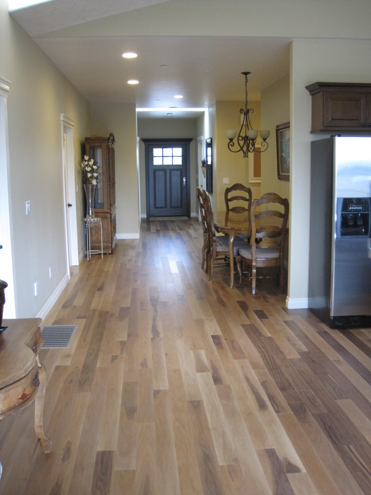 A view of a kitchen and dining area with hardwood flooring in a home interior.