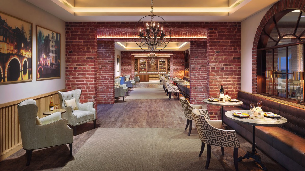 An elegant restaurant interior with brick walls, featuring a cozy dining area and a chandelier.