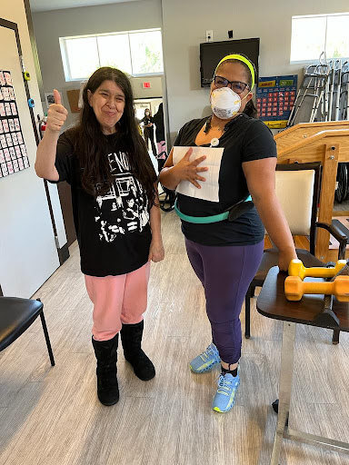 Two individuals engaging in a fitness activity indoors, demonstrating teamwork and support.