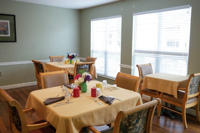 A cozy dining room with neatly set tables and ample natural light.