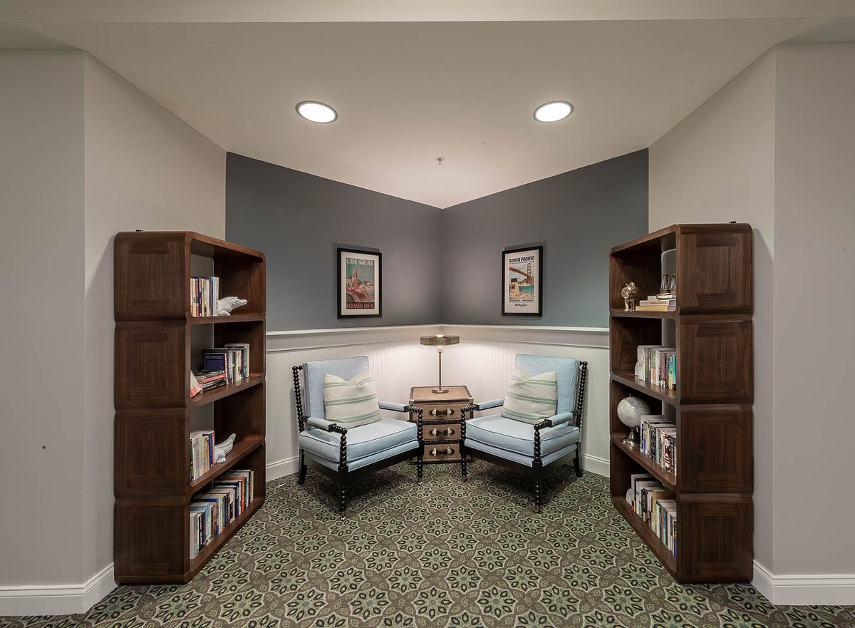 A cozy reading nook with comfortable chairs and bookshelves on either side.