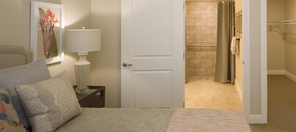 A cozy bedroom with a view into an adjacent bathroom.