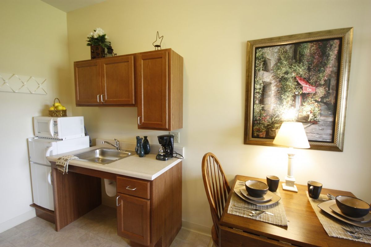 A cozy kitchen with wooden cabinets featuring a small dining area and homey decor.