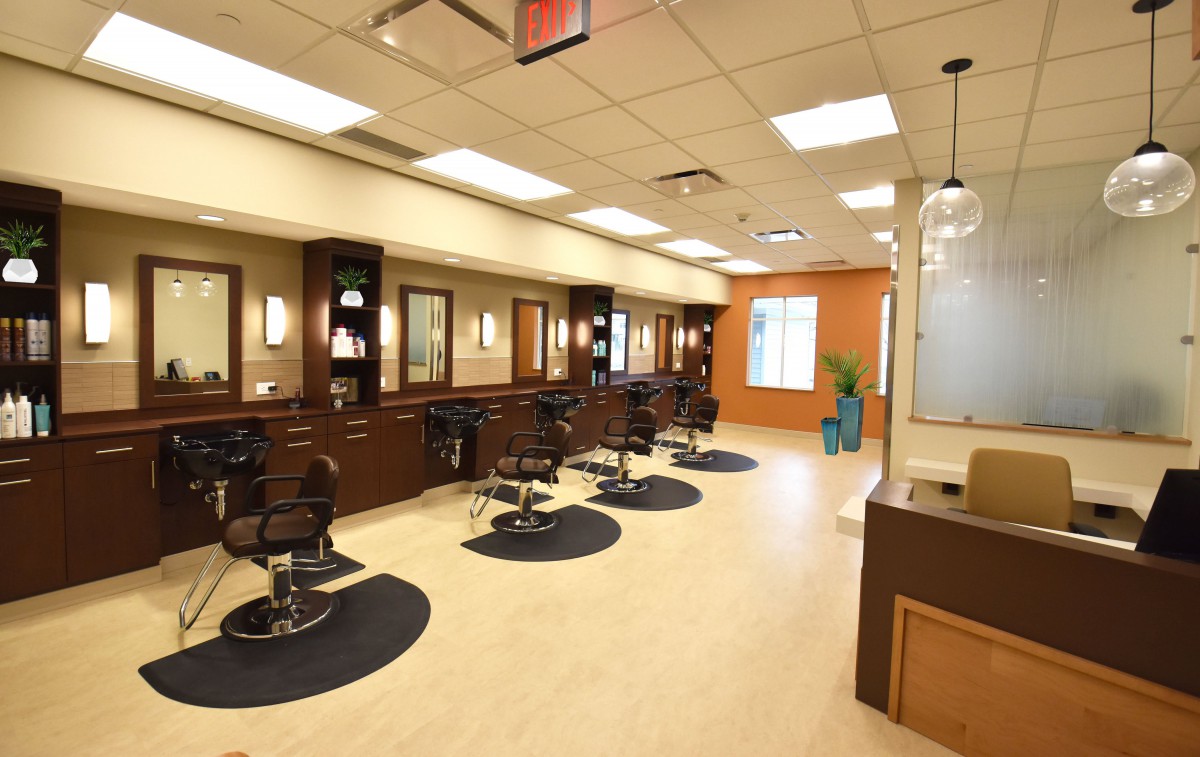 A modern hair salon interior with multiple styling stations and mirrors.