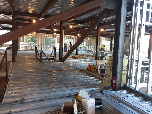 An interior view of a construction site showcasing steel beams and flooring in progress.