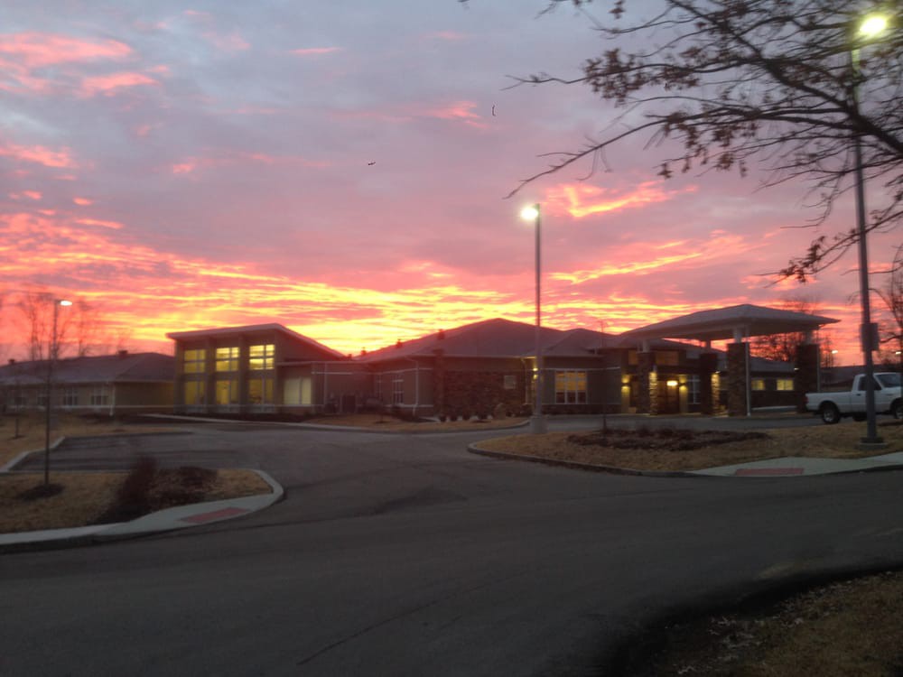 A picturesque sunset over a modern building with vibrant colors in the sky.