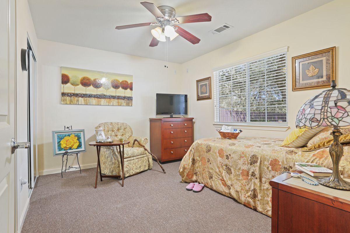 A cozy bedroom with a comfortable bed, TV, and seating area.