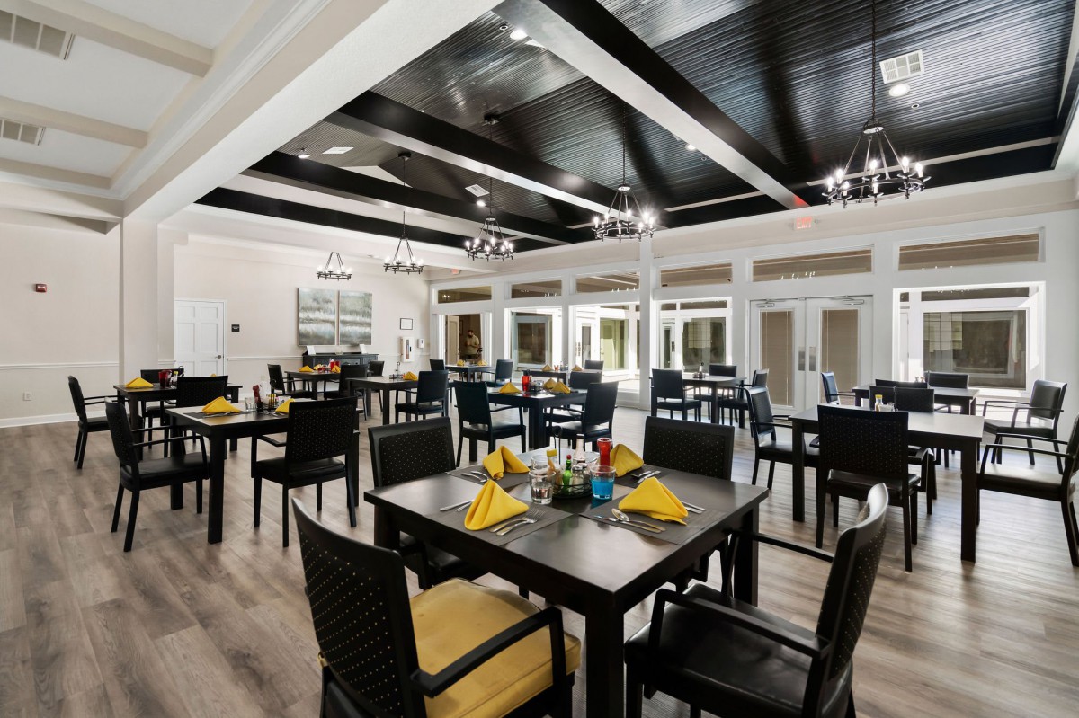 A well-lit, elegant dining area with neatly arranged tables and chairs.