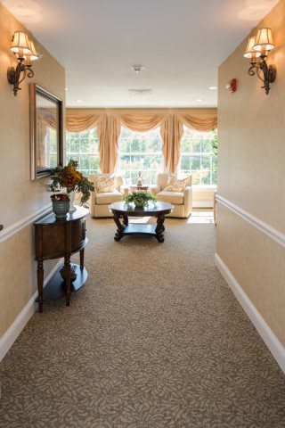 A well-decorated hallway with elegant furniture and large windows.