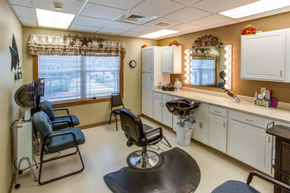 A tidy hair salon interior with chairs, mirrors, and a styling station.