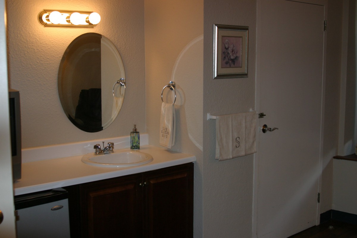 A clean and modern bathroom with a mirror, sink, and towels.