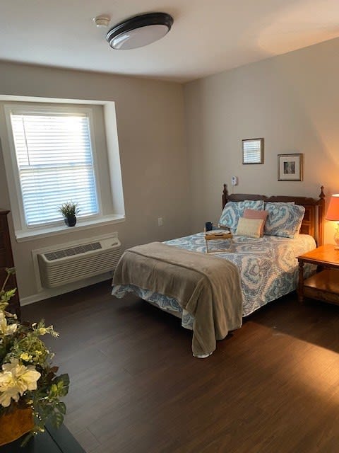 A cozy bedroom with a neatly made bed, soft lighting, and simple decor.