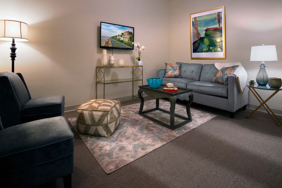 A modern living room with stylish decor, featuring a comfortable sofa, a coffee table, and a flat-screen TV.