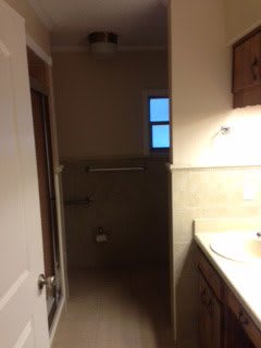 A small bathroom with a sink, mirror, and towel bar.