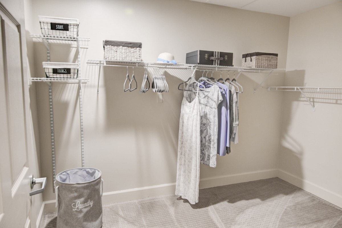 A minimalist closet with organized clothing and storage boxes.