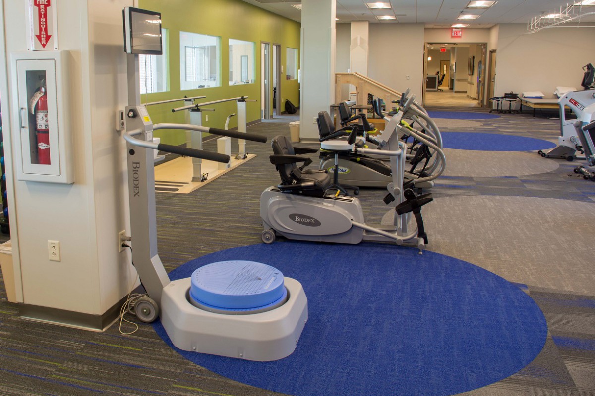A rehabilitation gym equipped with various exercise machines for physical therapy.