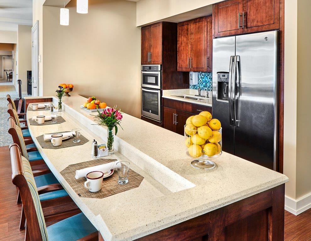 A modern kitchen with a sleek countertop adorned with lemons and set for dining.