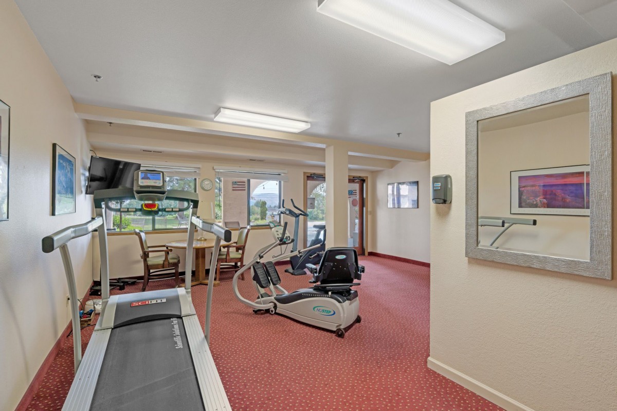 A small fitness room equipped with a treadmill and exercise bike.