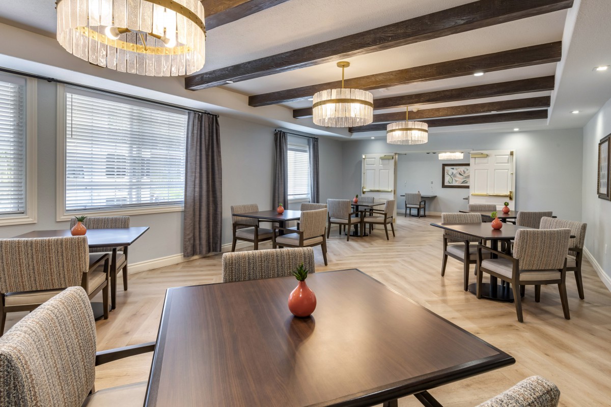 A modern dining room with neatly arranged tables and stylish lighting fixtures.
