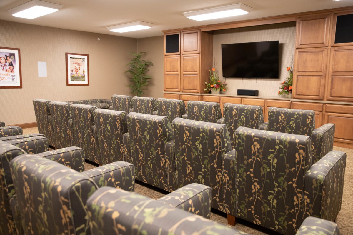 A cozy home theater with patterned seating and a large flat-screen TV.