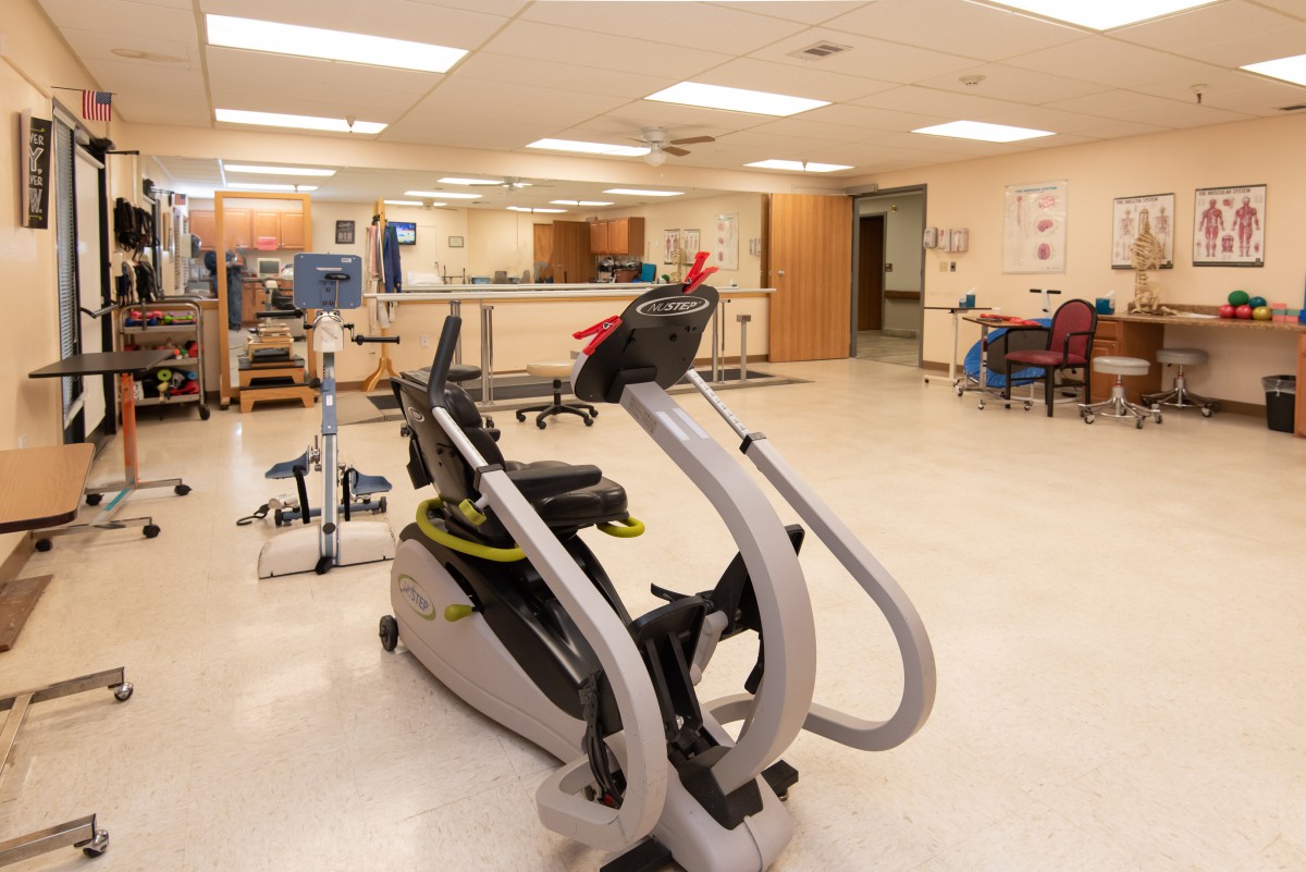 A rehabilitation room equipped with exercise machines and medical equipment.