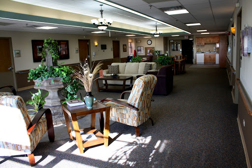 A welcoming lobby area featuring comfortable seating and greenery, illuminated by natural light.