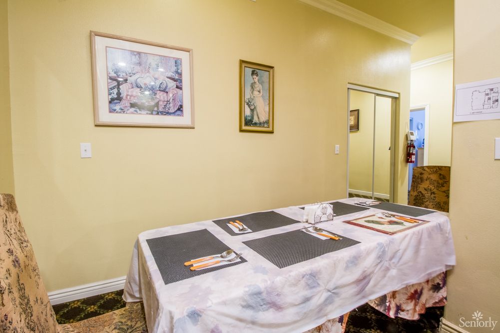 A dining area with a table set with placemats and wall art decorations.