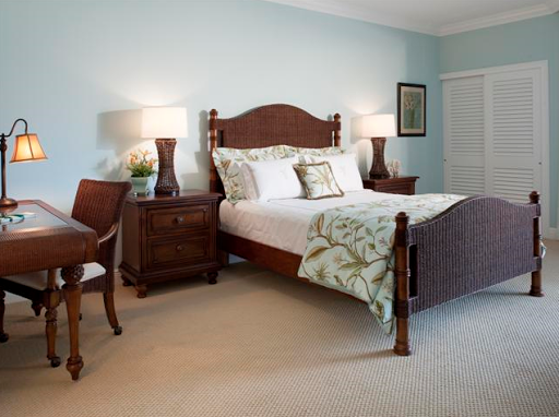A beautifully designed bedroom featuring elegant wooden furniture and soft blue walls.