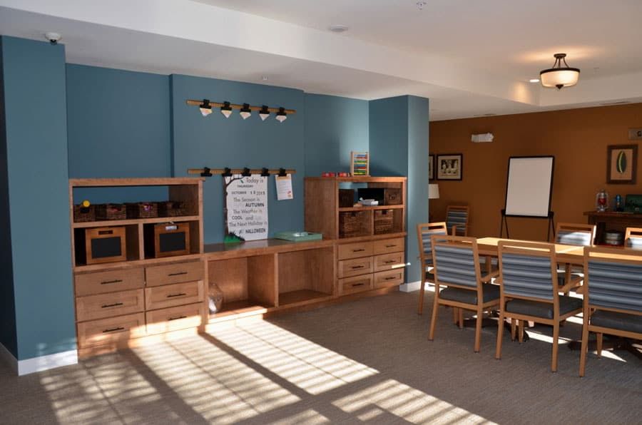 A well-organized meeting room with a large conference table and wooden shelves against blue walls.
