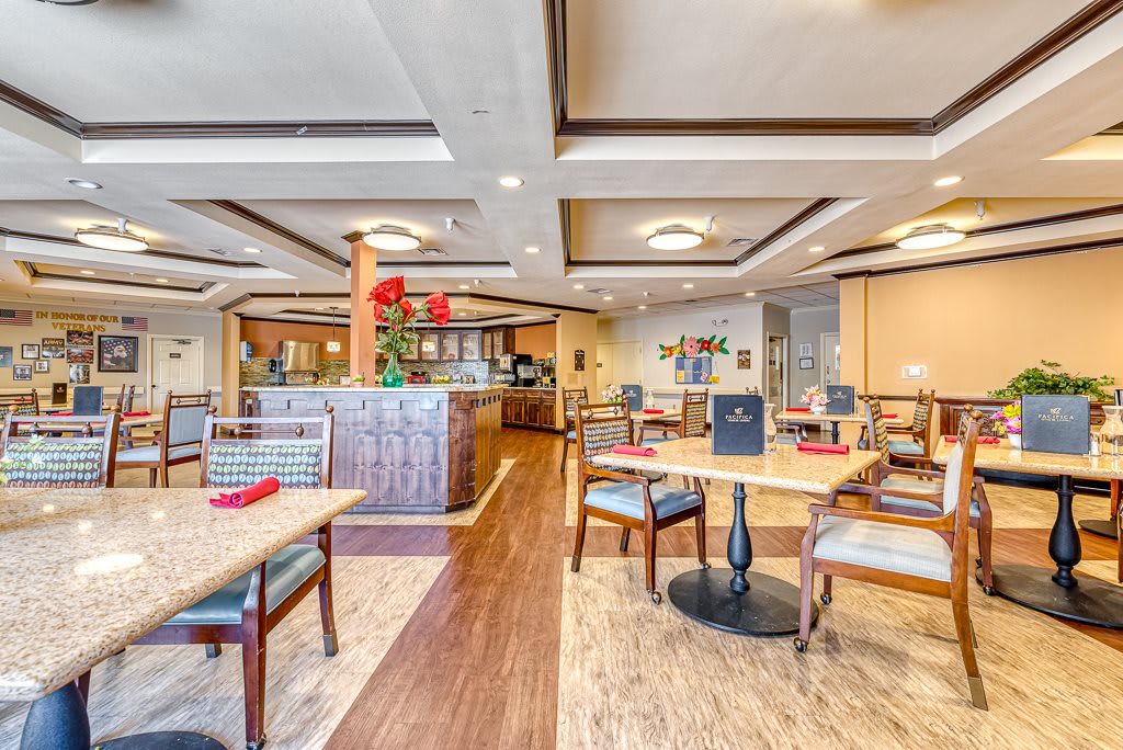 A brightly lit restaurant interior with neatly arranged tables and chairs.
