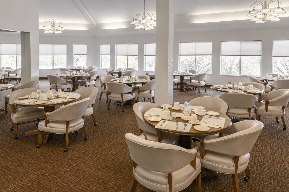 An elegant dining room with neatly set tables and comfortable chairs.