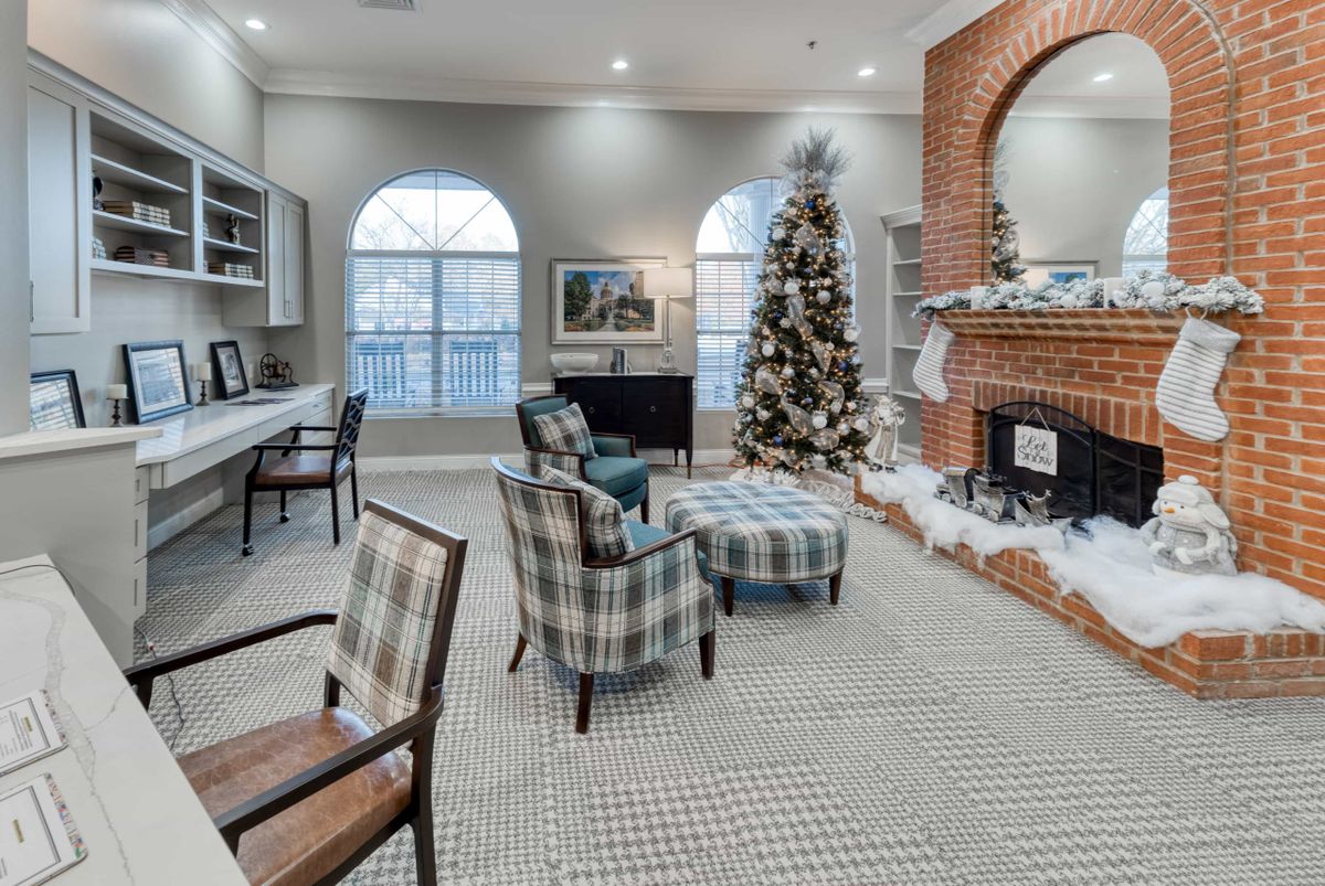 A cozy living room adorned with festive holiday decorations, featuring a Christmas tree and a warm fireplace.
